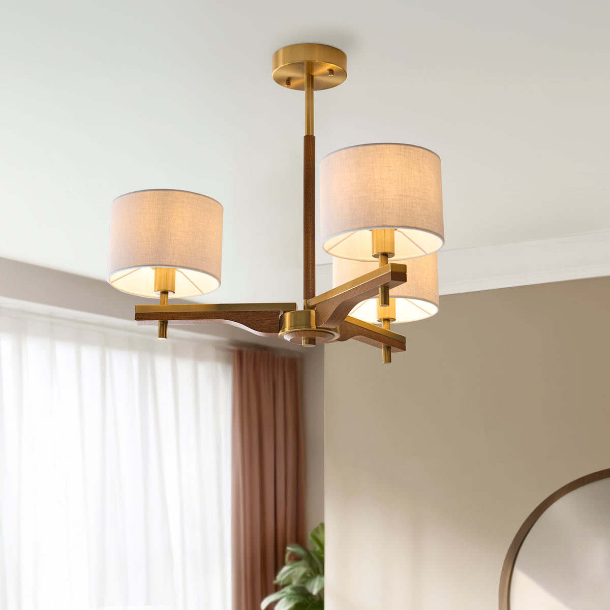 Modern chandelier with three fabric shades and a wooden frame, hanging from a white ceiling.