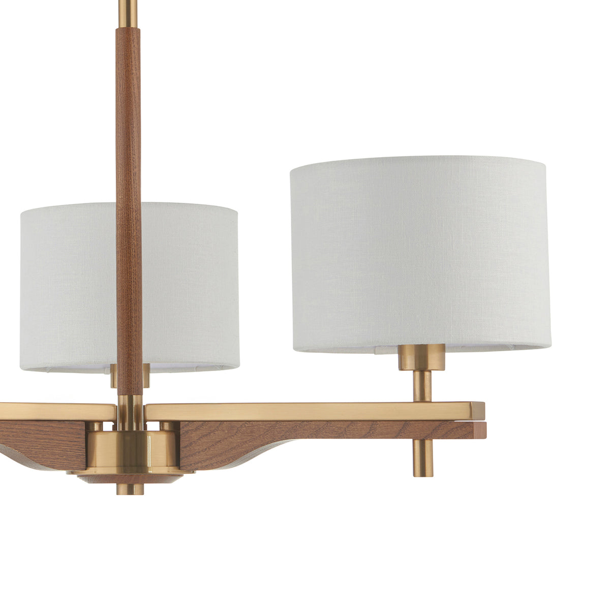 Close-up of a modern chandelier with two white fabric shades, brass accents, and a wooden frame.