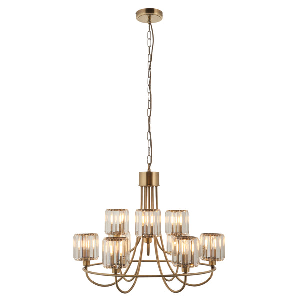 A brass chandelier with nine clear, fluted glass shades, each housing a glowing bulb, on a white background.