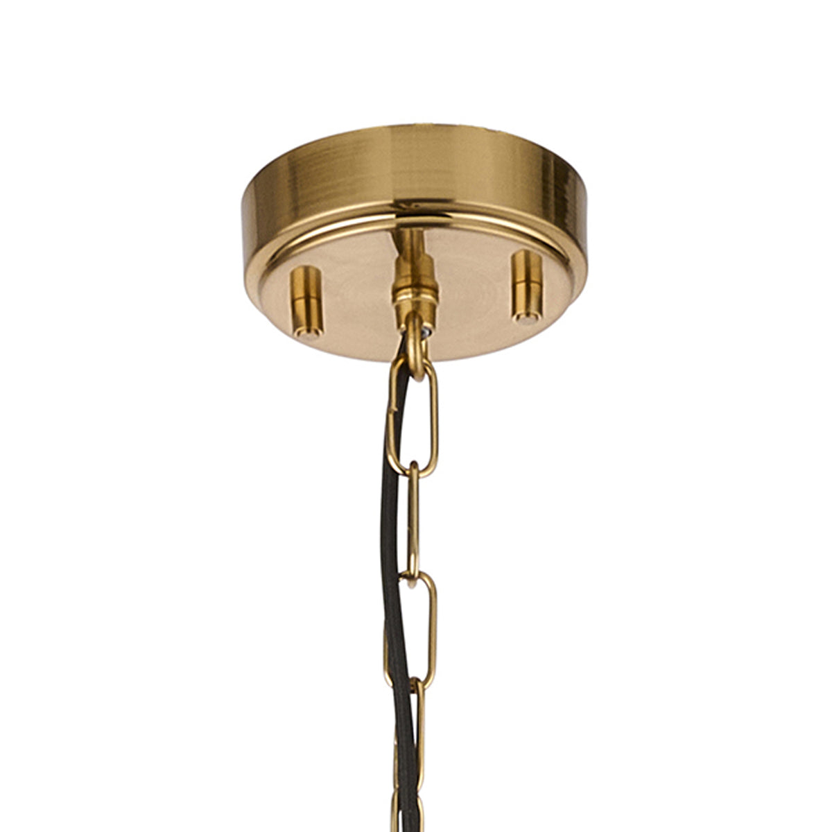 Close-up of a brass ceiling rose with a hanging chain and black electrical cord.