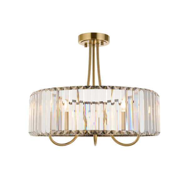 Round brass chandelier with vertical clear crystal panels, casting rainbow reflections.