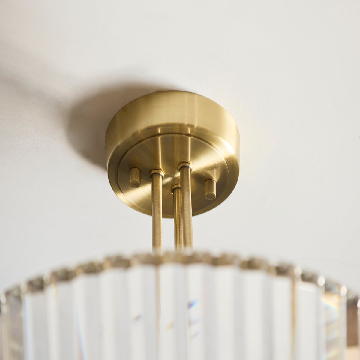 Close-up of a brass ceiling light fixture with a fluted glass shade.