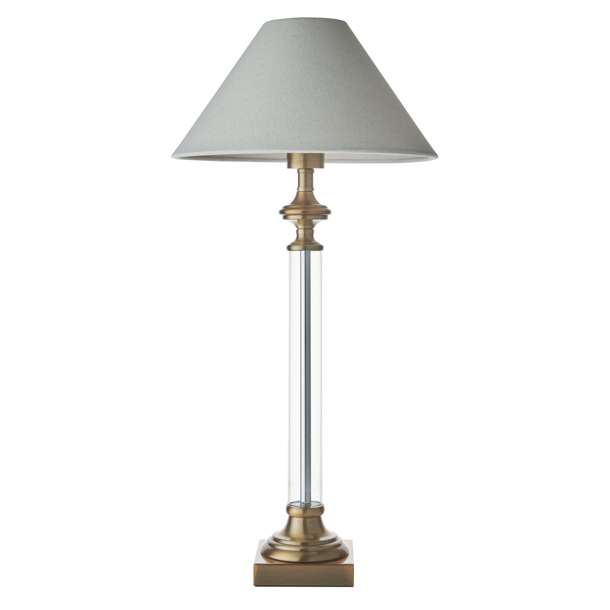 Table lamp with a light grey shade, a clear glass column, and a bronze base and accents. 