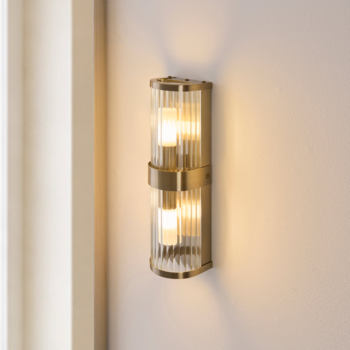 Ridgeton IP44 Twin Wall Light in Antique Brass with Clear Ribbed Glass