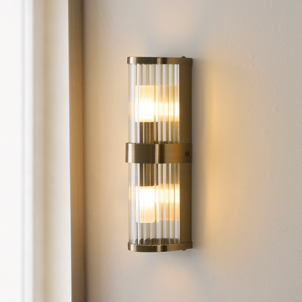 Ridgeton IP44 Twin Wall Light in Antique Brass with Clear Ribbed Glass