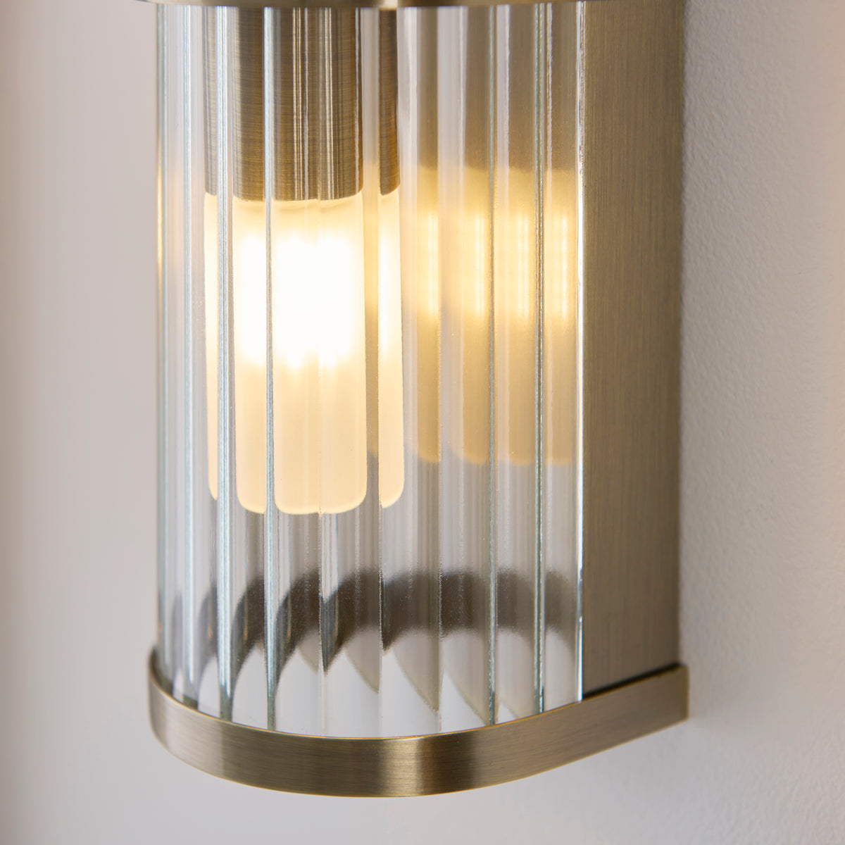 Endon Lighting Ridgeton IP44 twin wall light in antique brass with clear ribbed glass