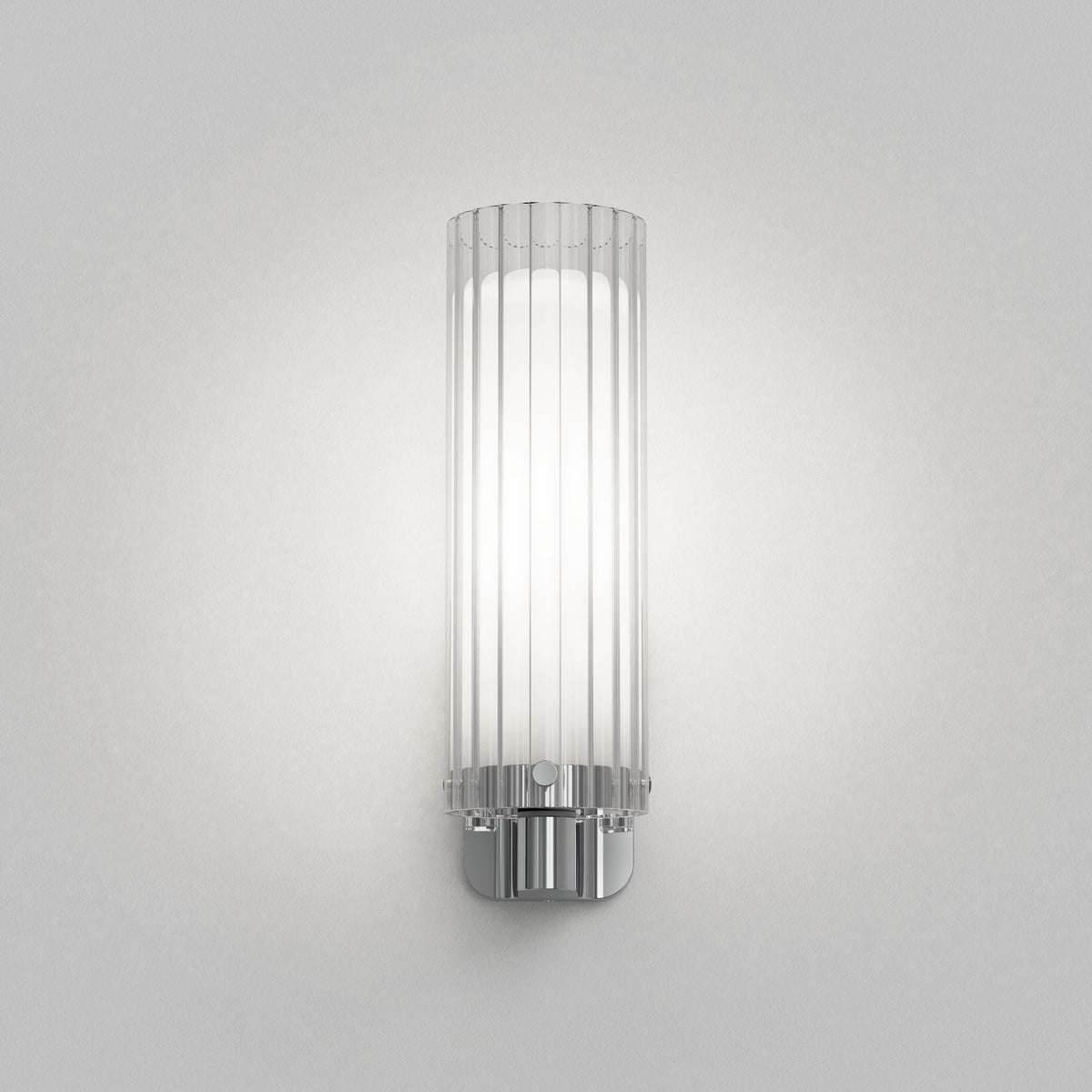 Fluted glass wall sconce with a polished chrome base and a white light source