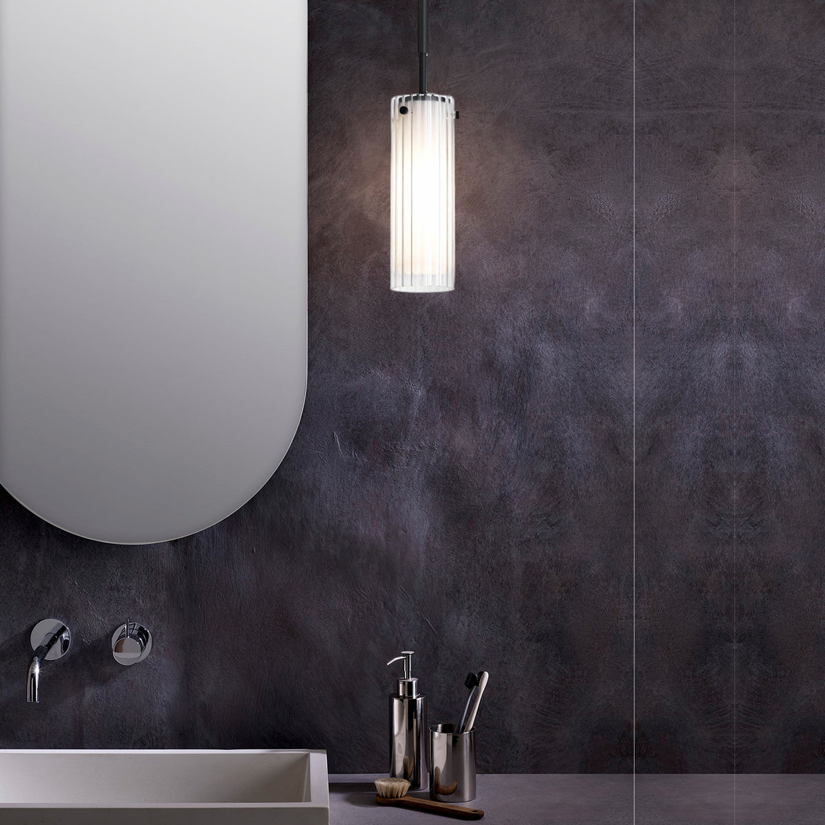 Modern bathroom with a white oval mirror, a white sink, and a cylindrical pendant light