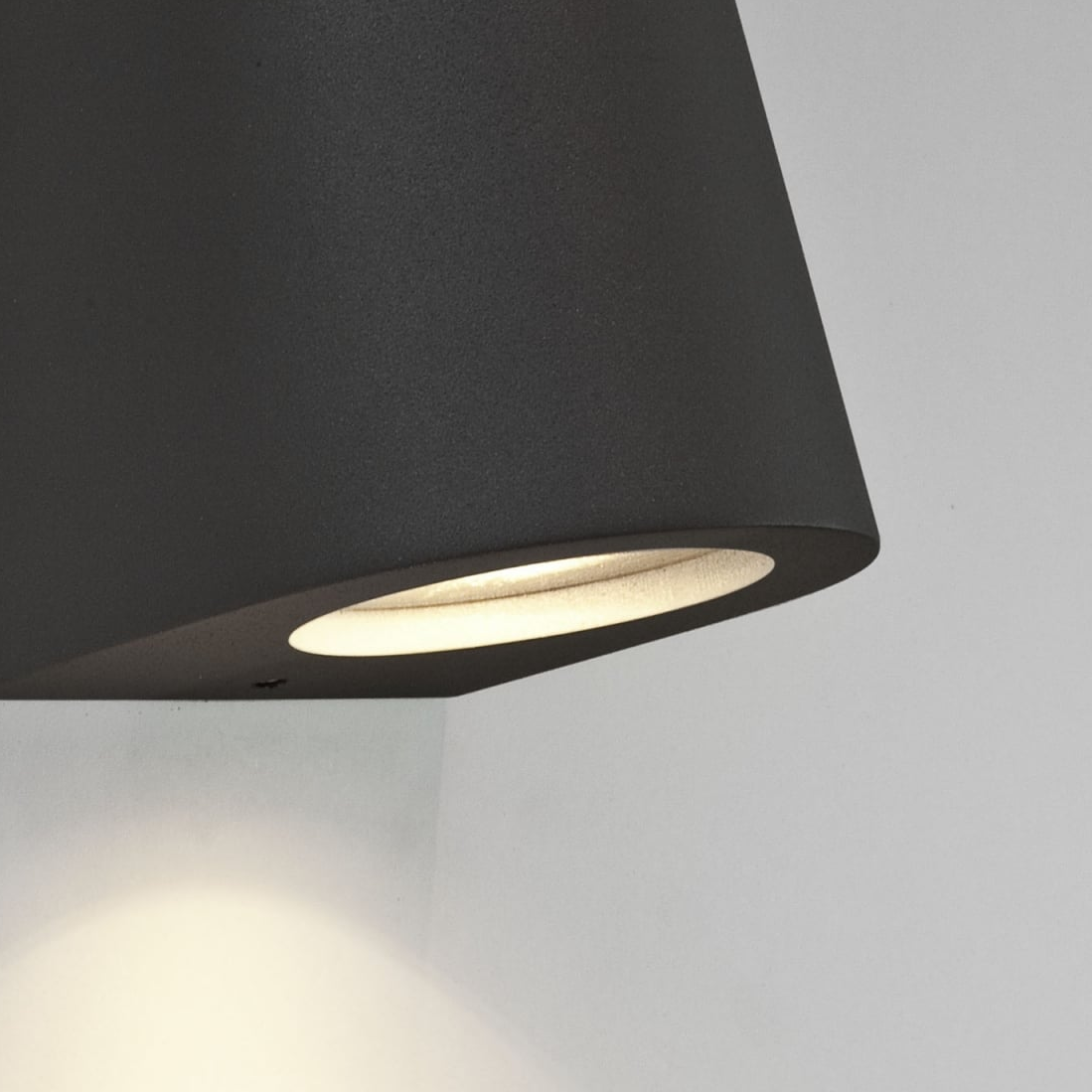 Close up of a black outdoor wall light with a textured finish