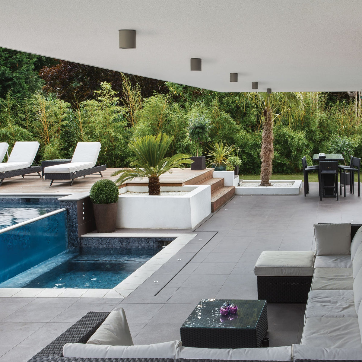 Outdoor patio with a swimming pool, lounge chairs, a dining table, and a sofa set