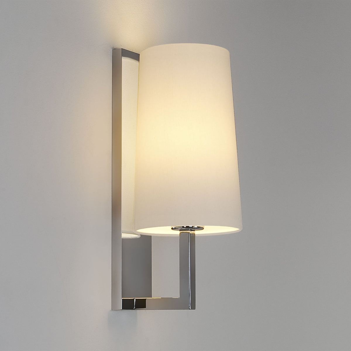 Wall mounted lamp with a white conical shade and a polished chrome rectangular base