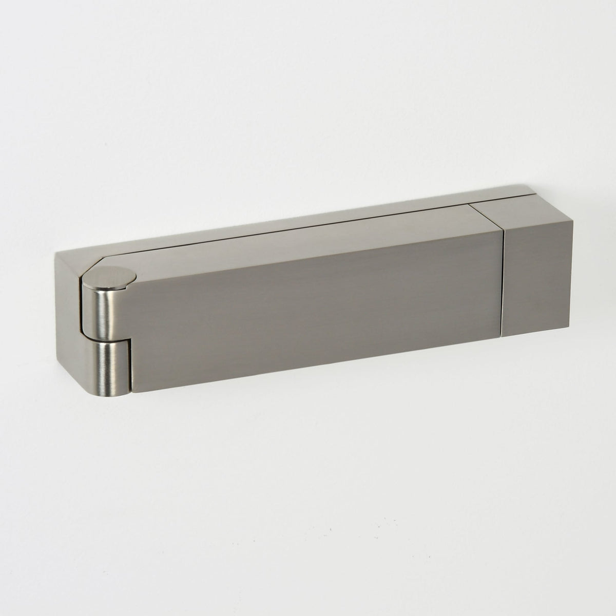 Rectangular satin nickel hinge with a rounded end, mounted on a white wall
