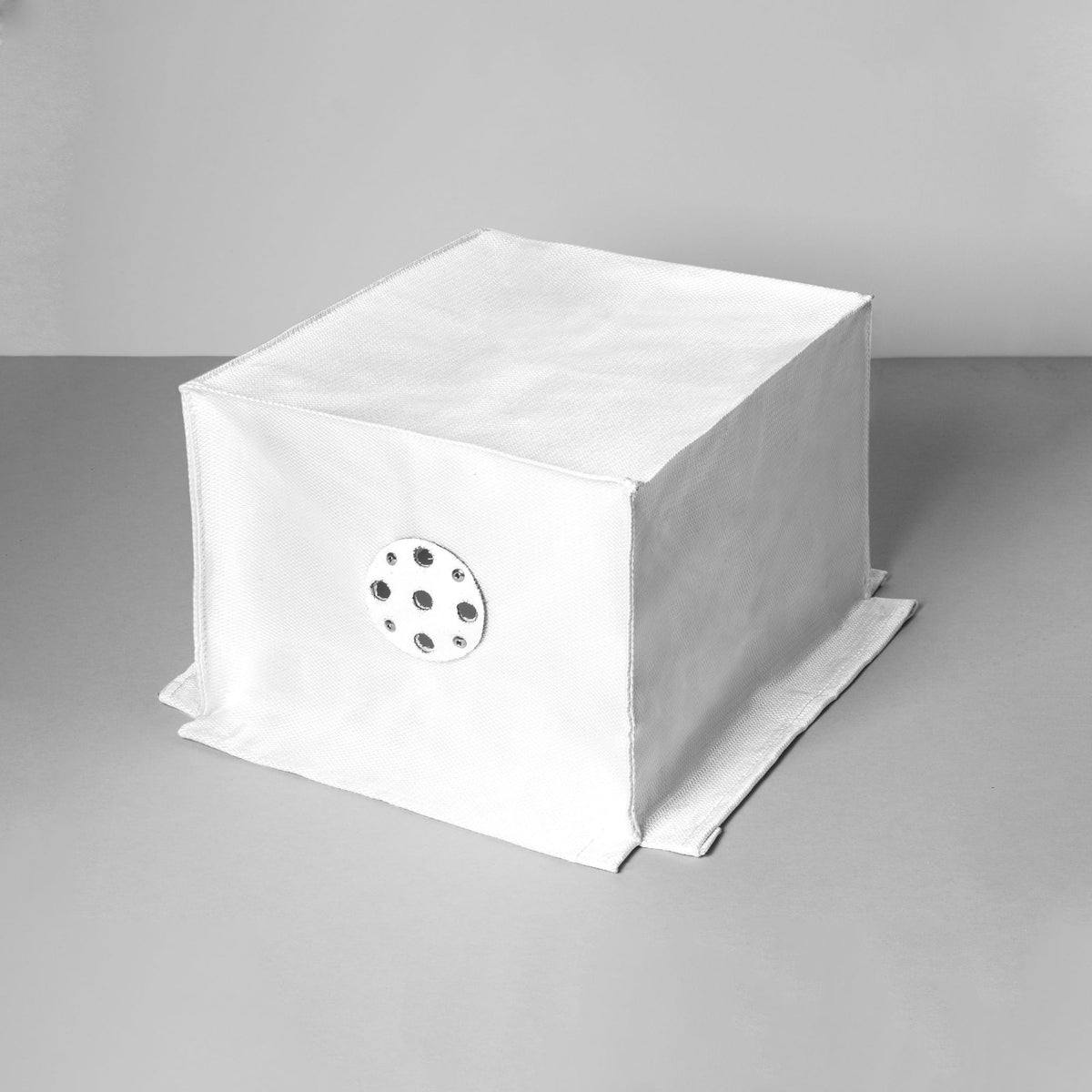 White fabric box with a circular metal vent on one side