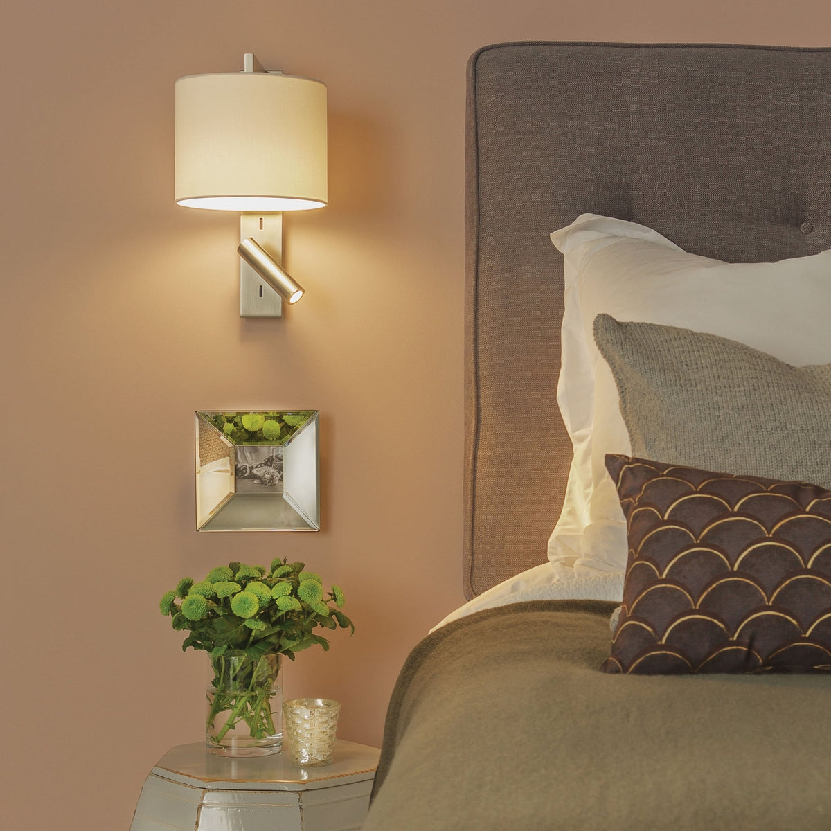Wall mounted bedside lamp with a fabric shade and a directional reading light