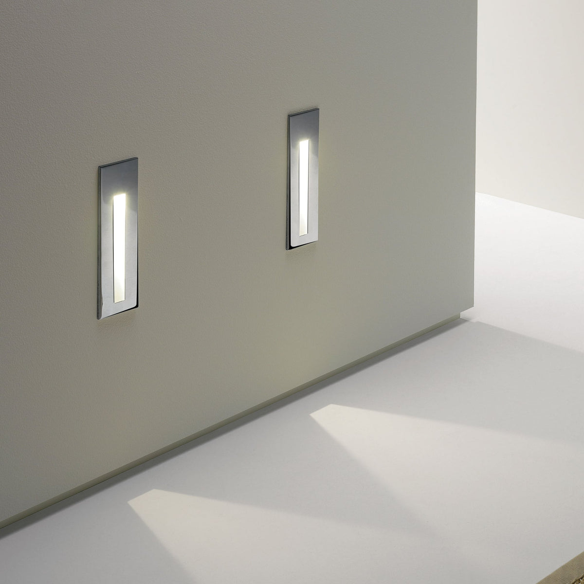 Two rectangular wall lights with a silver finish and a vertical strip of light