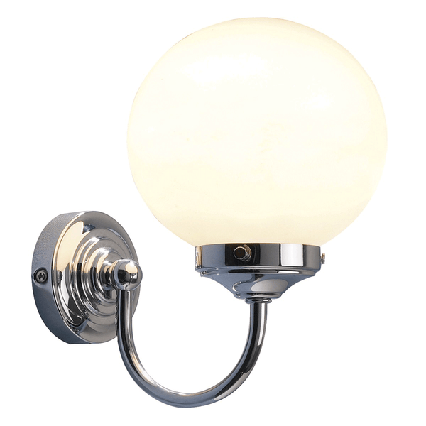 A polished chrome wall light with a white globe shade, emitting a warm glow.