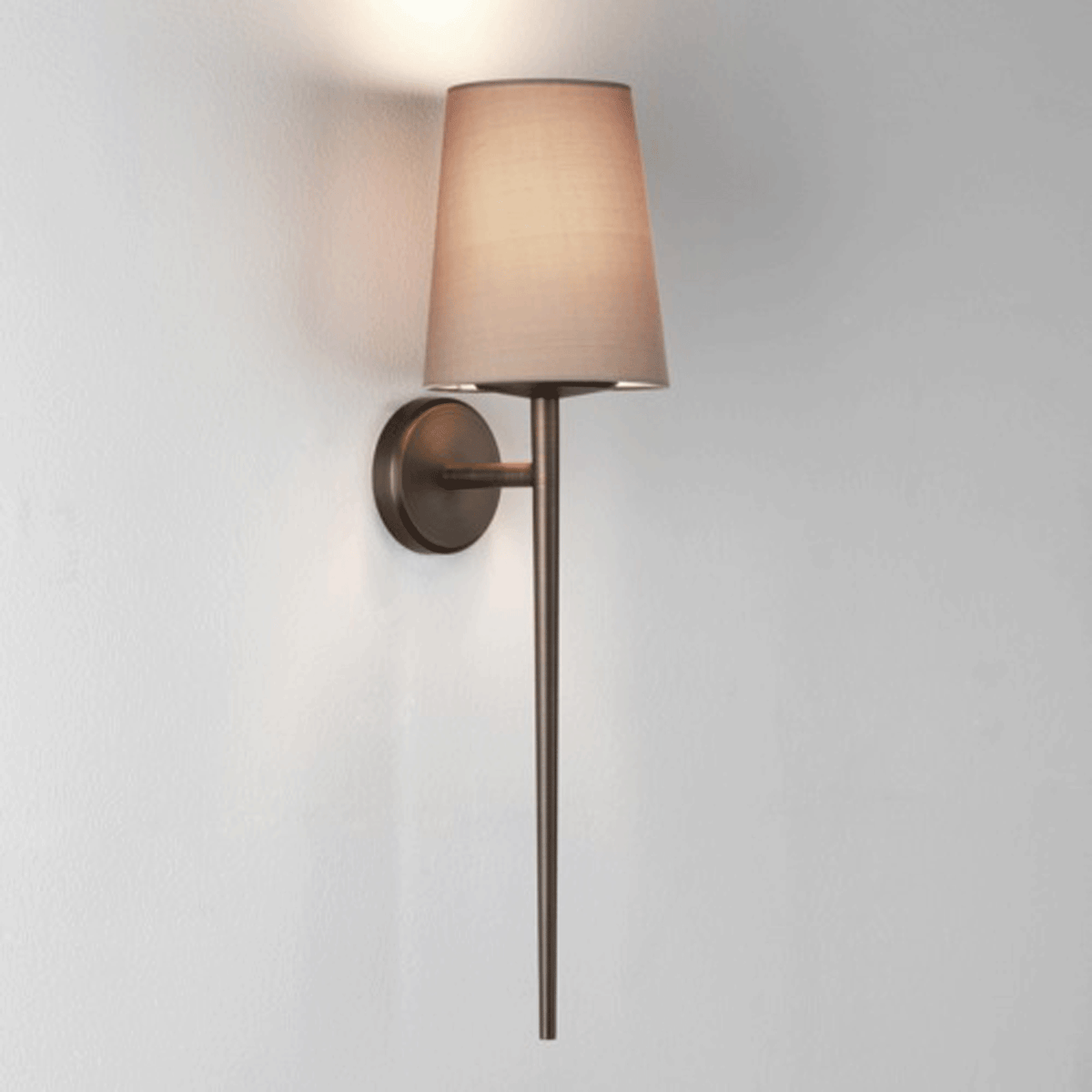 Wall mounted lamp with a bronze base and a light brown fabric shade