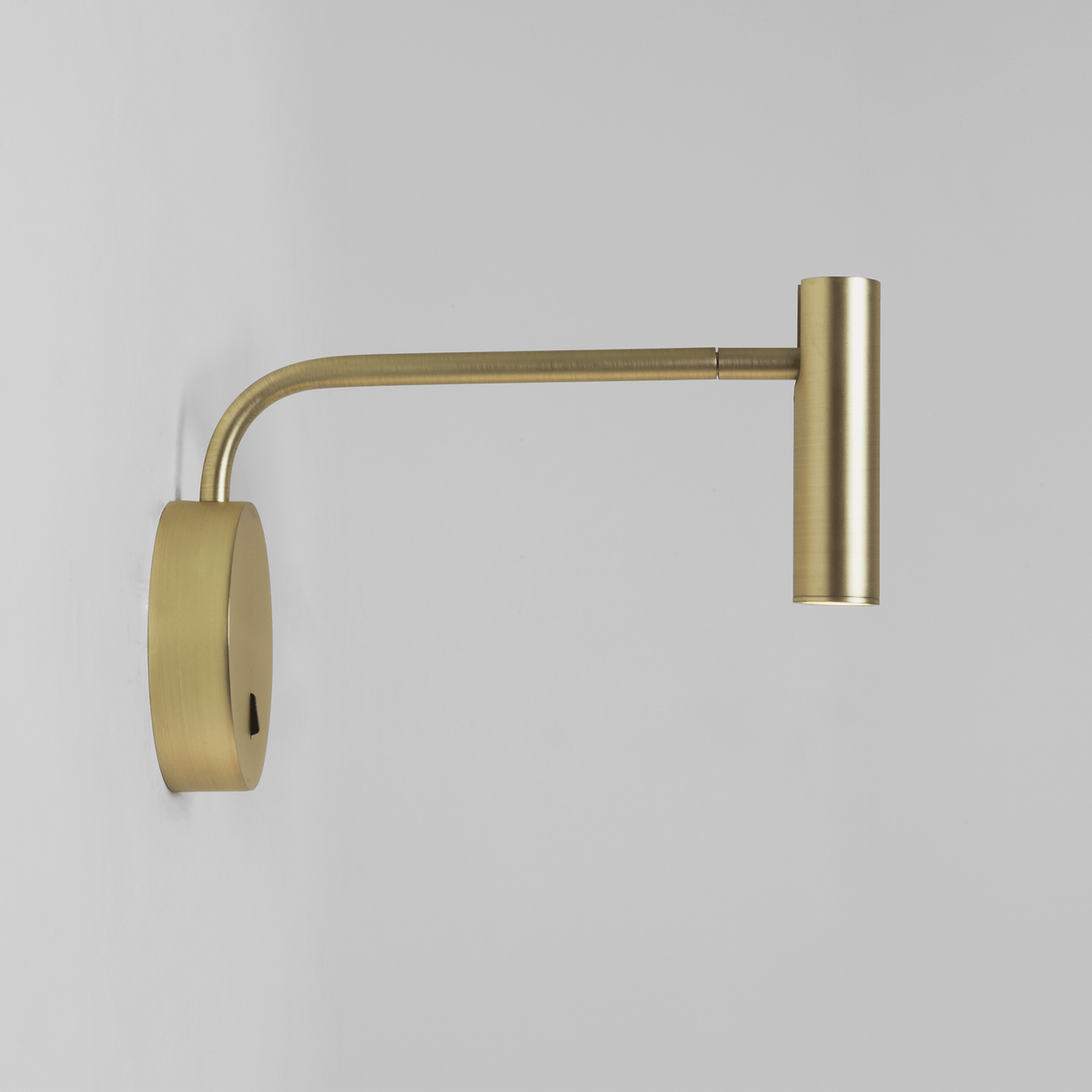 Brass wall light with a curved arm and cylindrical head
