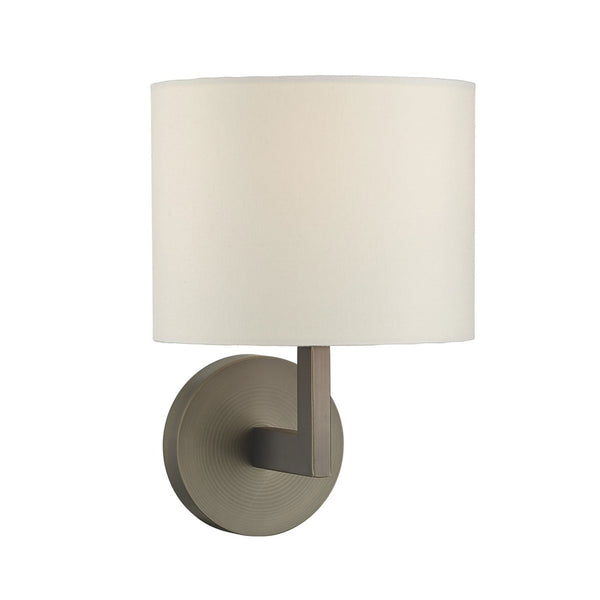 A modern wall sconce with a circular base, a straight arm, and a cylindrical white fabric shade.