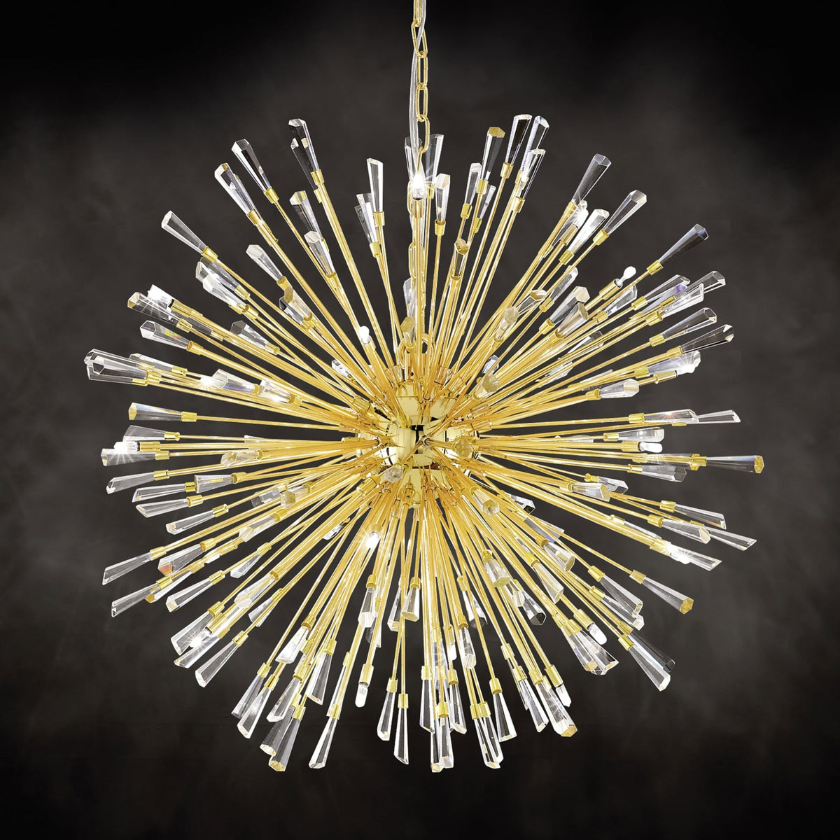 A gold pendant light with crystal rods on a dark background.