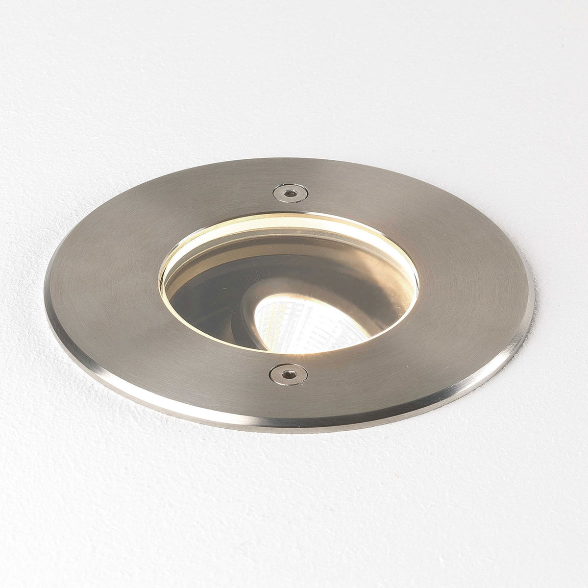 Round brushed metal recessed light with a warm glow