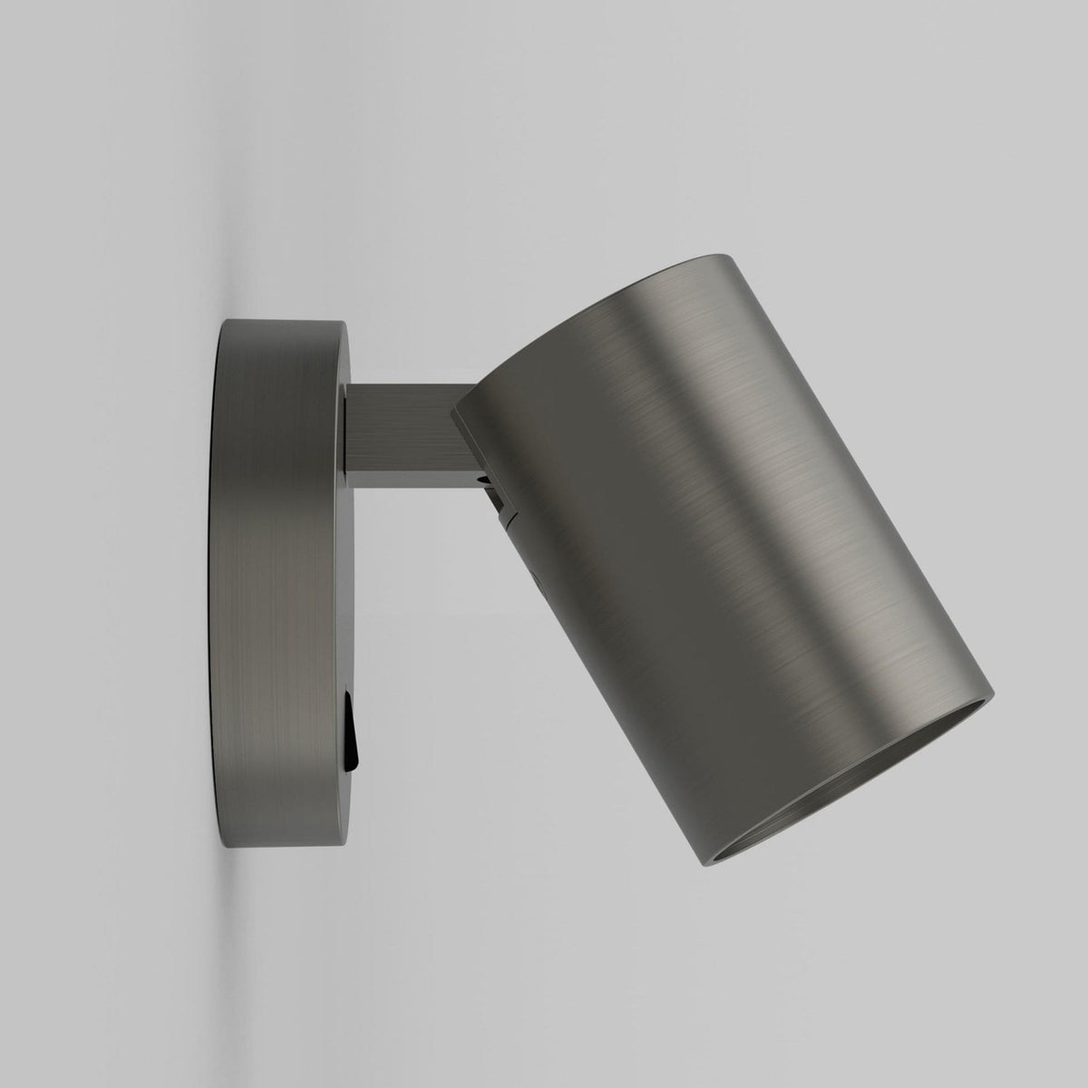 A side view of a brushed steel wall light with a cylindrical head, angled downwards.
