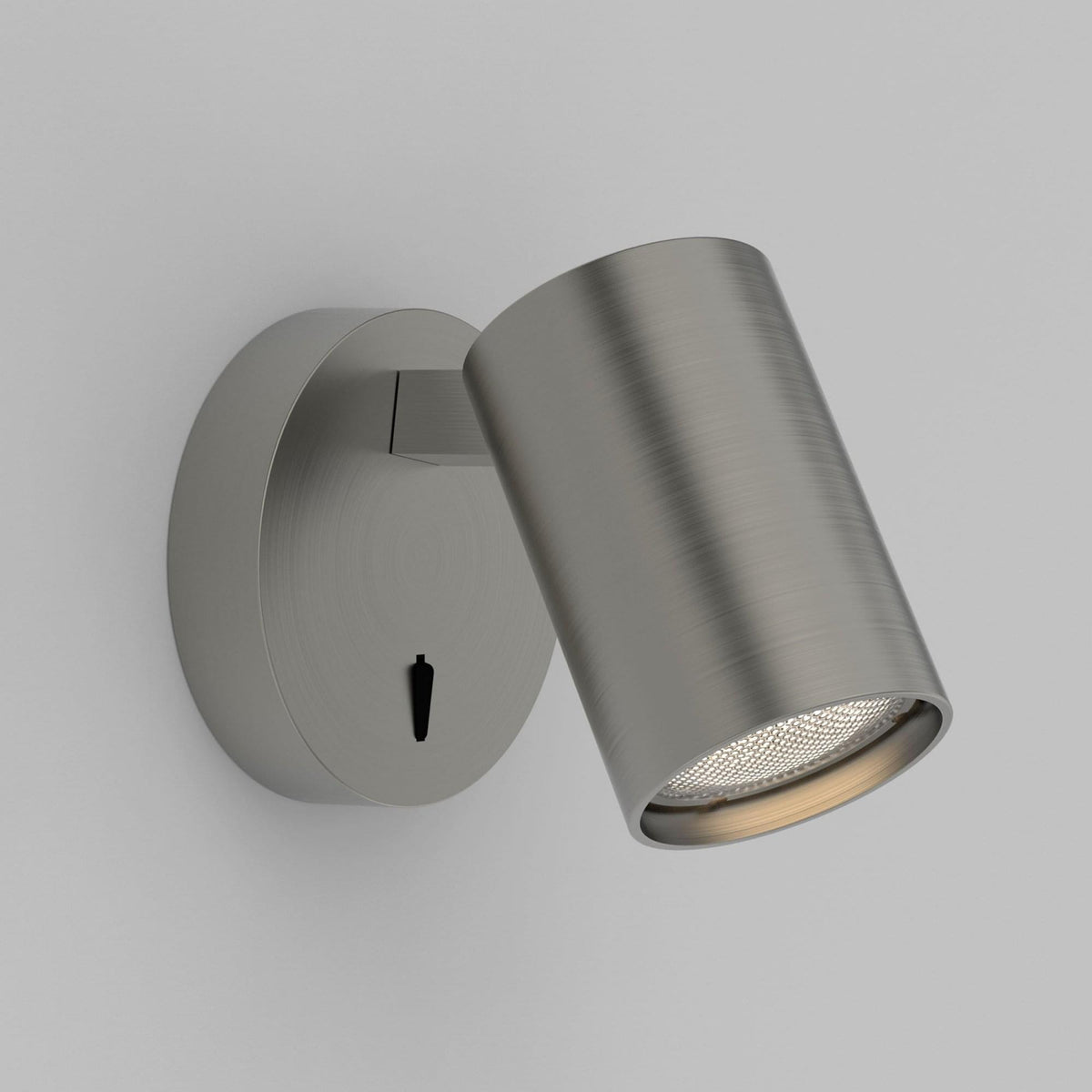 A brushed steel wall light with a cylindrical head featuring an on/off switch.