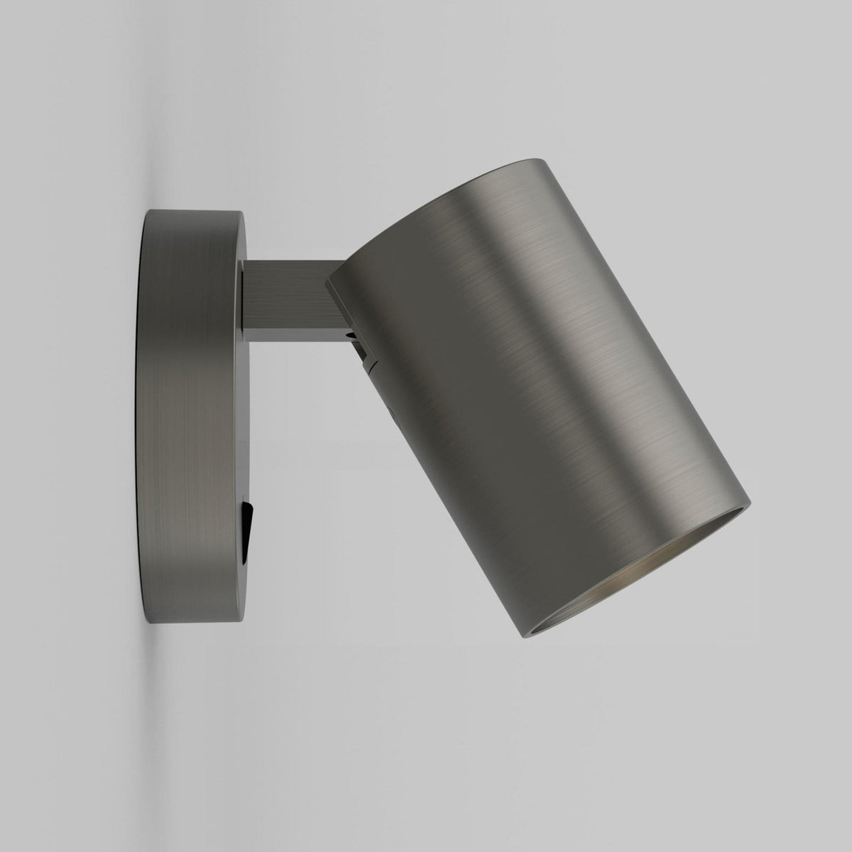 A side view of a brushed steel wall light with a cylindrical head, angled downwards.