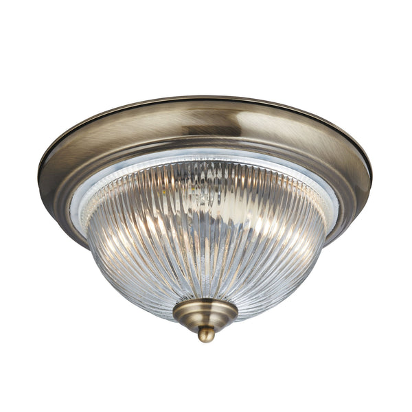 Traditional antique brass flush mount ceiling light with ribbed glass diffuser.
