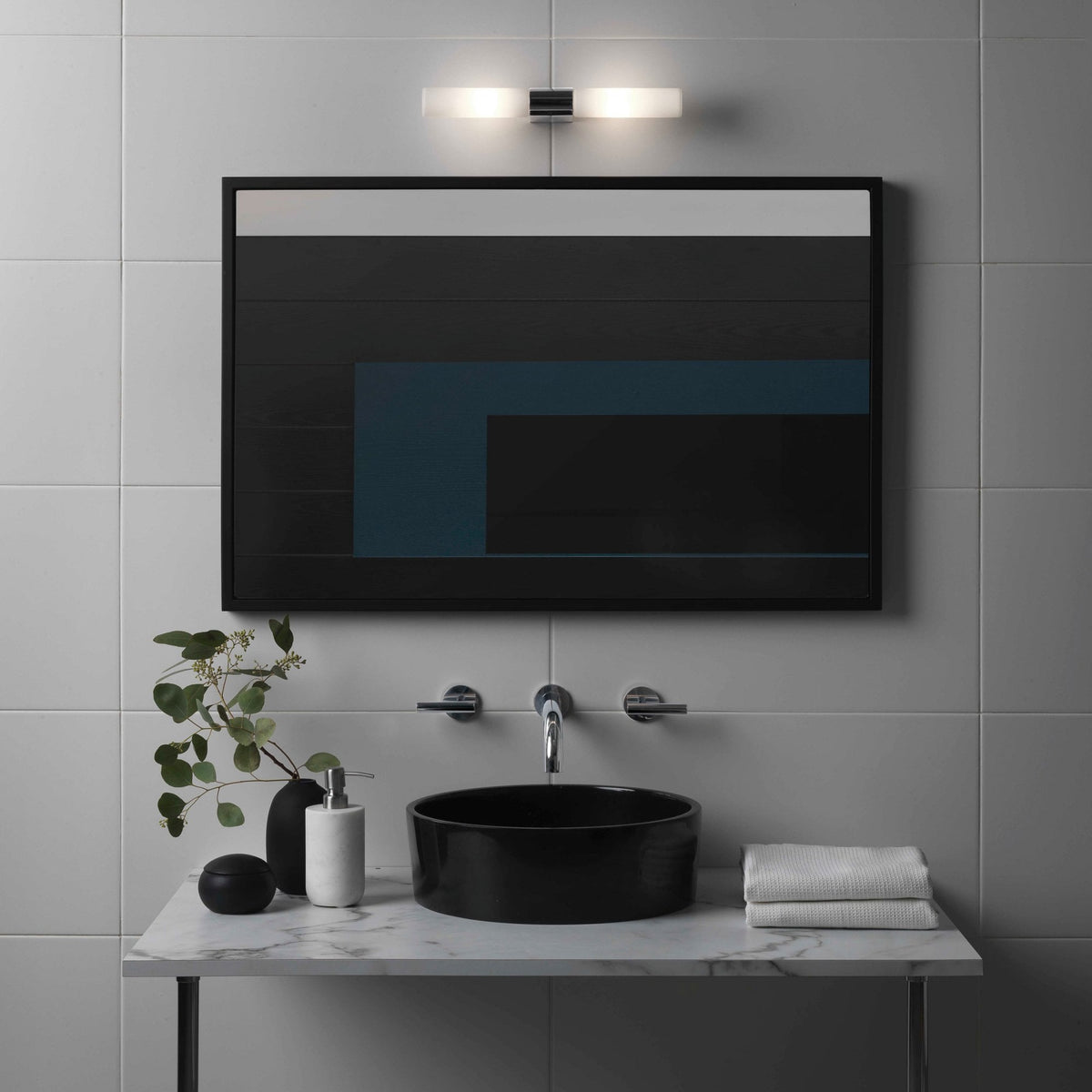 Bathroom vanity with black basin, marble countertop, and a mirror reflecting a dark abstract artwork