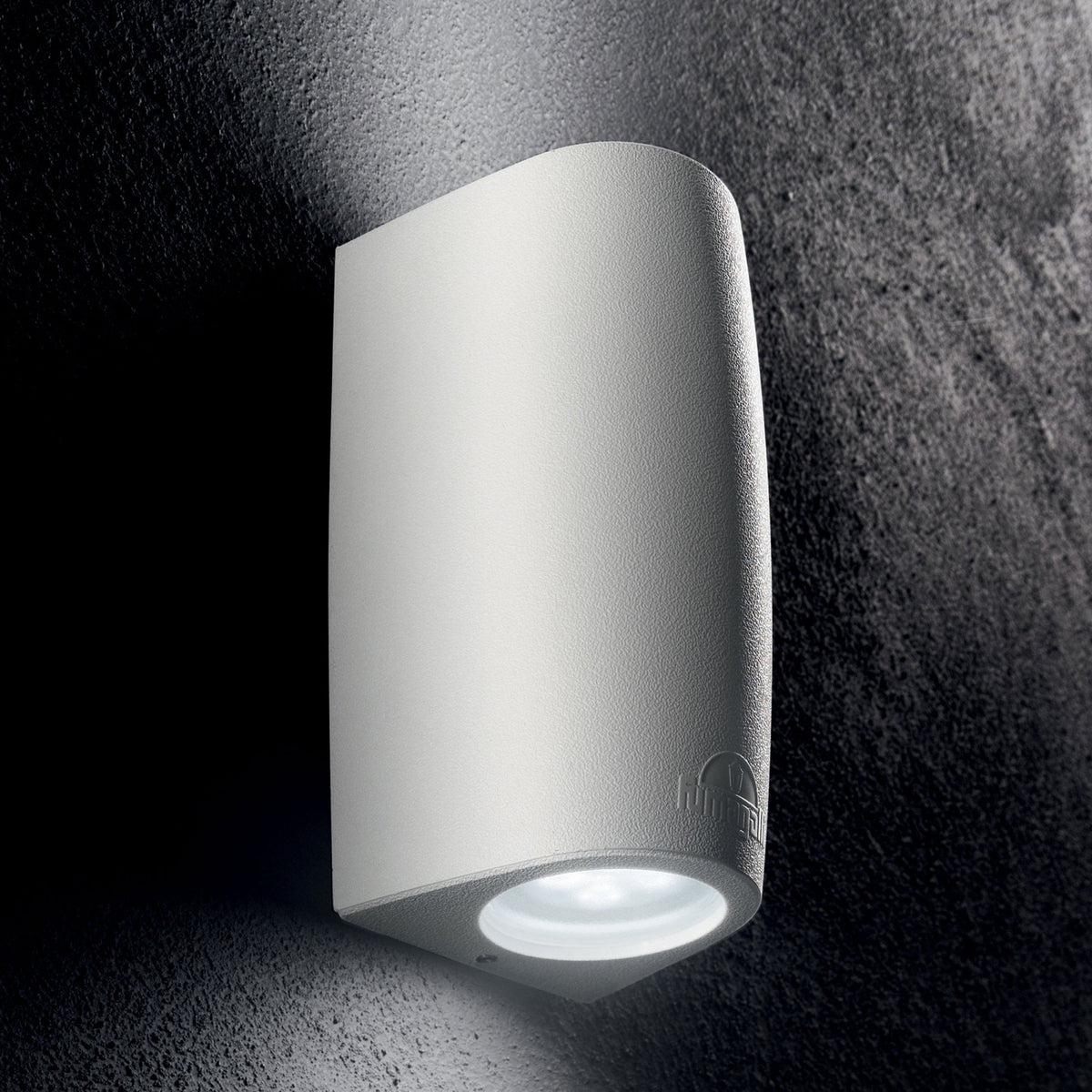 A white curved wall light with a downward-facing beam illuminates a textured dark wall.
