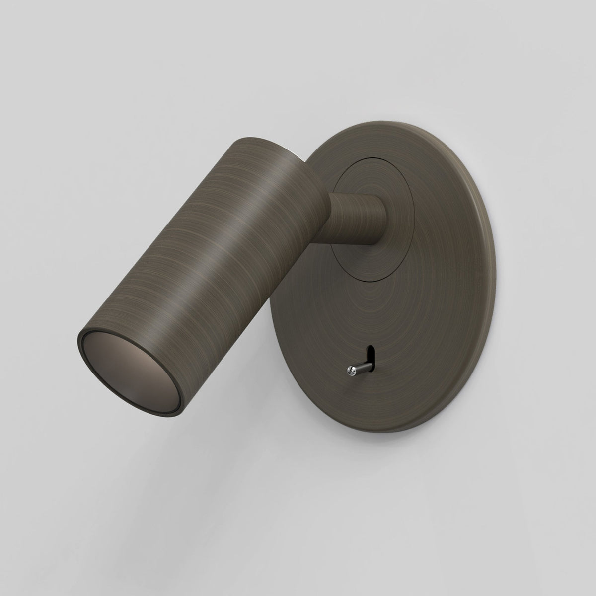 Bronze wall light with a cylindrical head and a round base, featuring a small pull switch