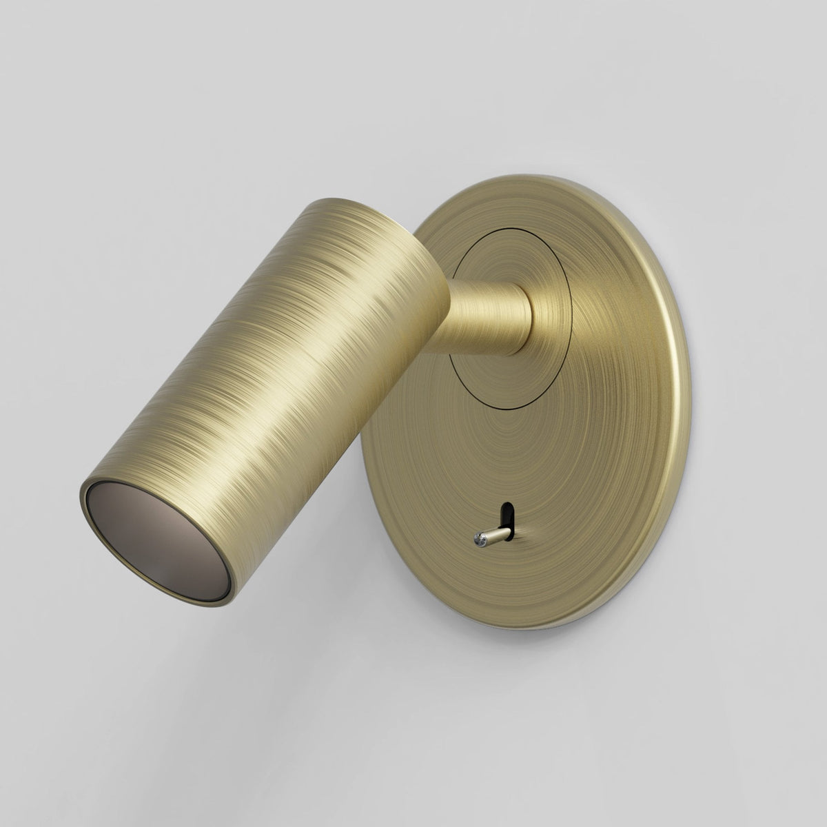 Brushed brass wall light with cylindrical head and circular base