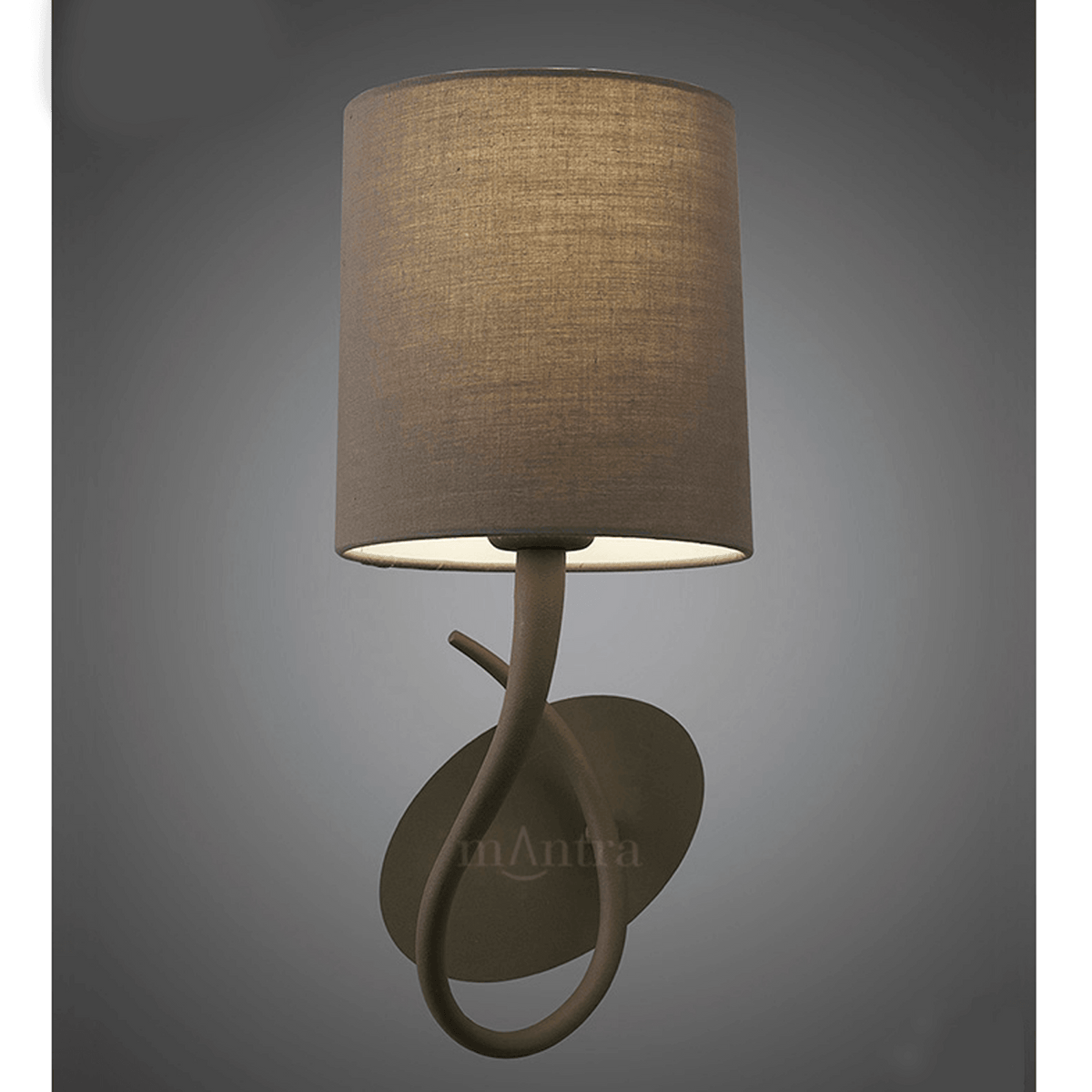 Brown wall light with a cylindrical fabric shade, casting a warm glow.