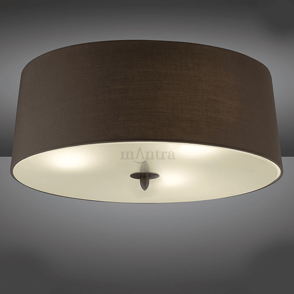 A close-up of a brown ceiling light with a wide drum shade.