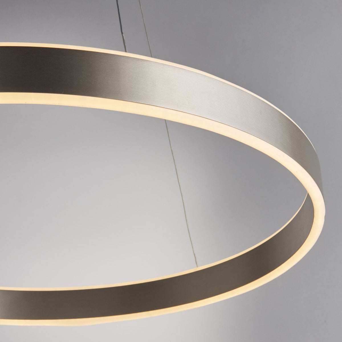 Close-up of a circular LED pendant light, showing the brushed nickel finish and illuminated inner edge.