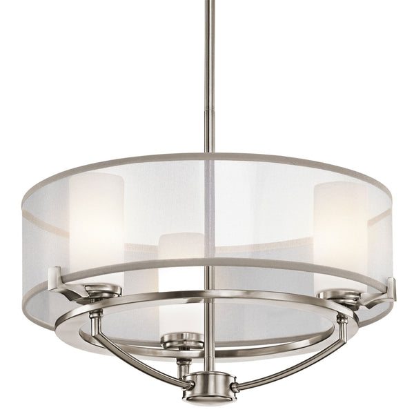 A contemporary pendant light featuring a brushed nickel finish and a white fabric drum shade.