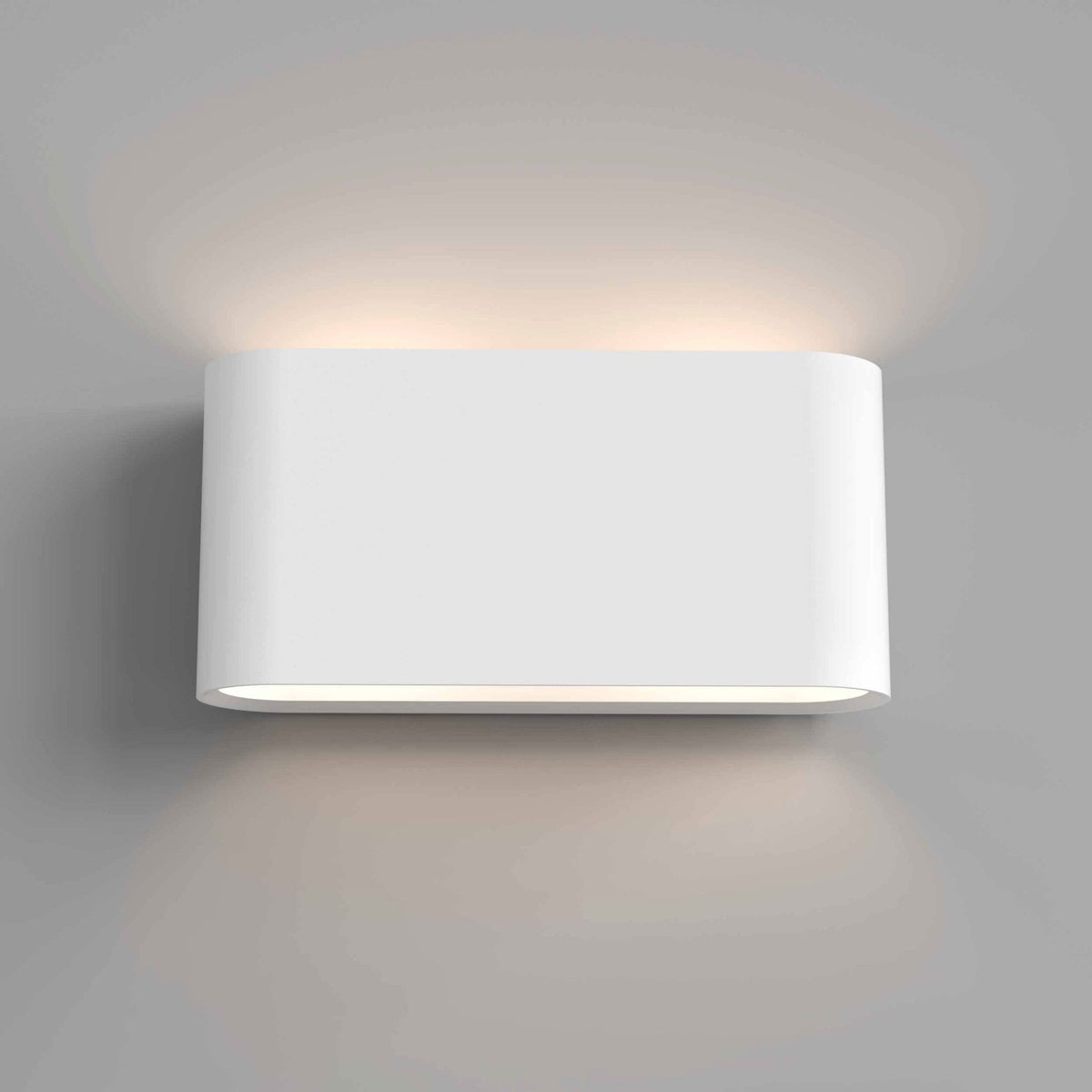 White rectangular wall light with rounded edges, emitting light upwards and downwards on a grey wall