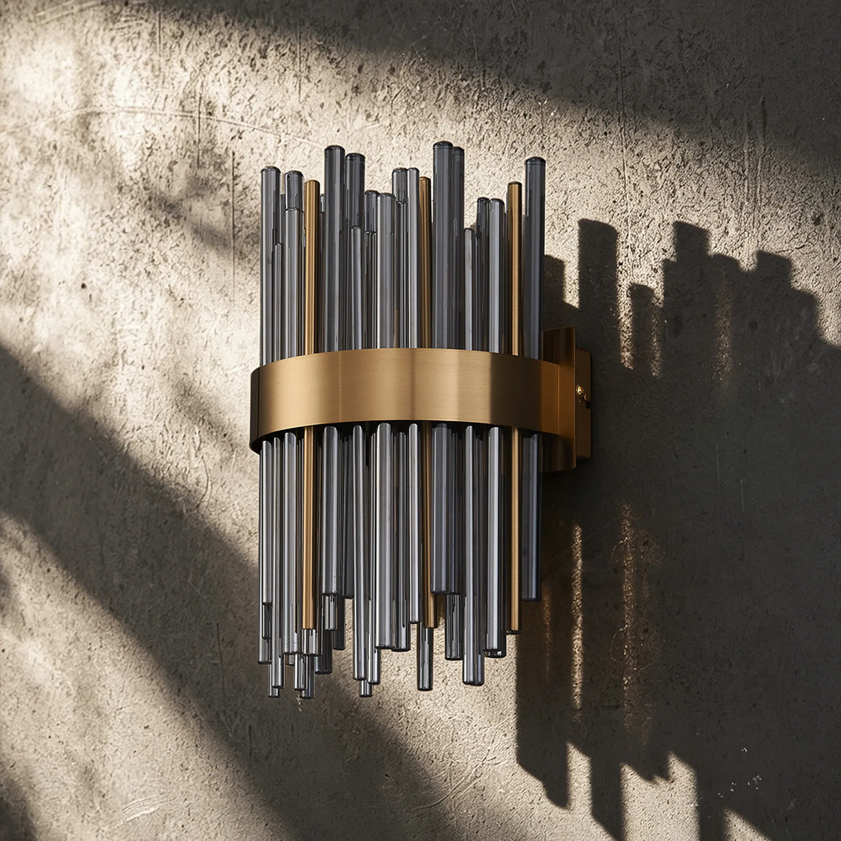 Wall sconce with vertical glass rods in clear and amber, held by a brass band