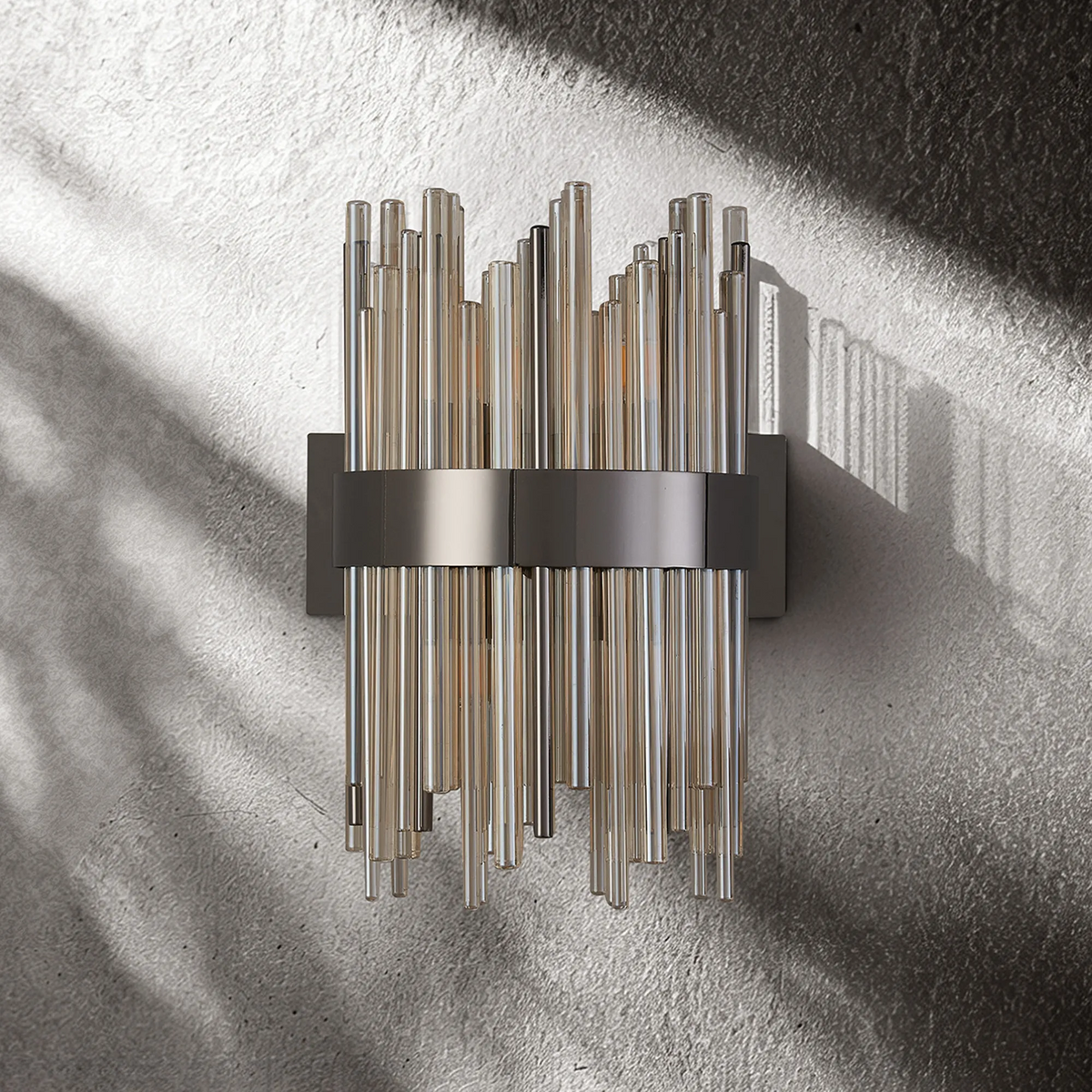 Wall sconce with multiple vertical glass rods in varying lengths, held by a horizontal metal band