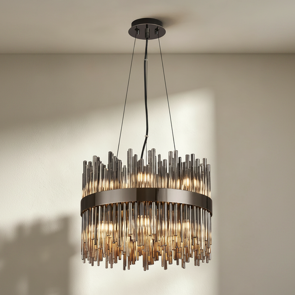 Round chandelier with dark metal frame and many vertical glass rods, lit from within