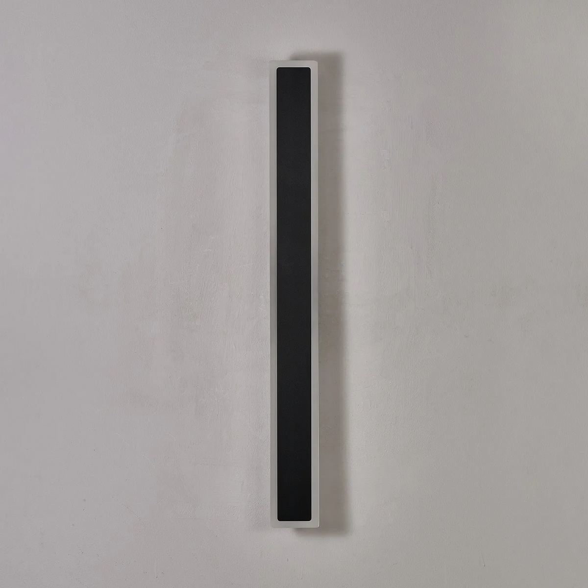 Vertical black and white wall light on a grey wall
