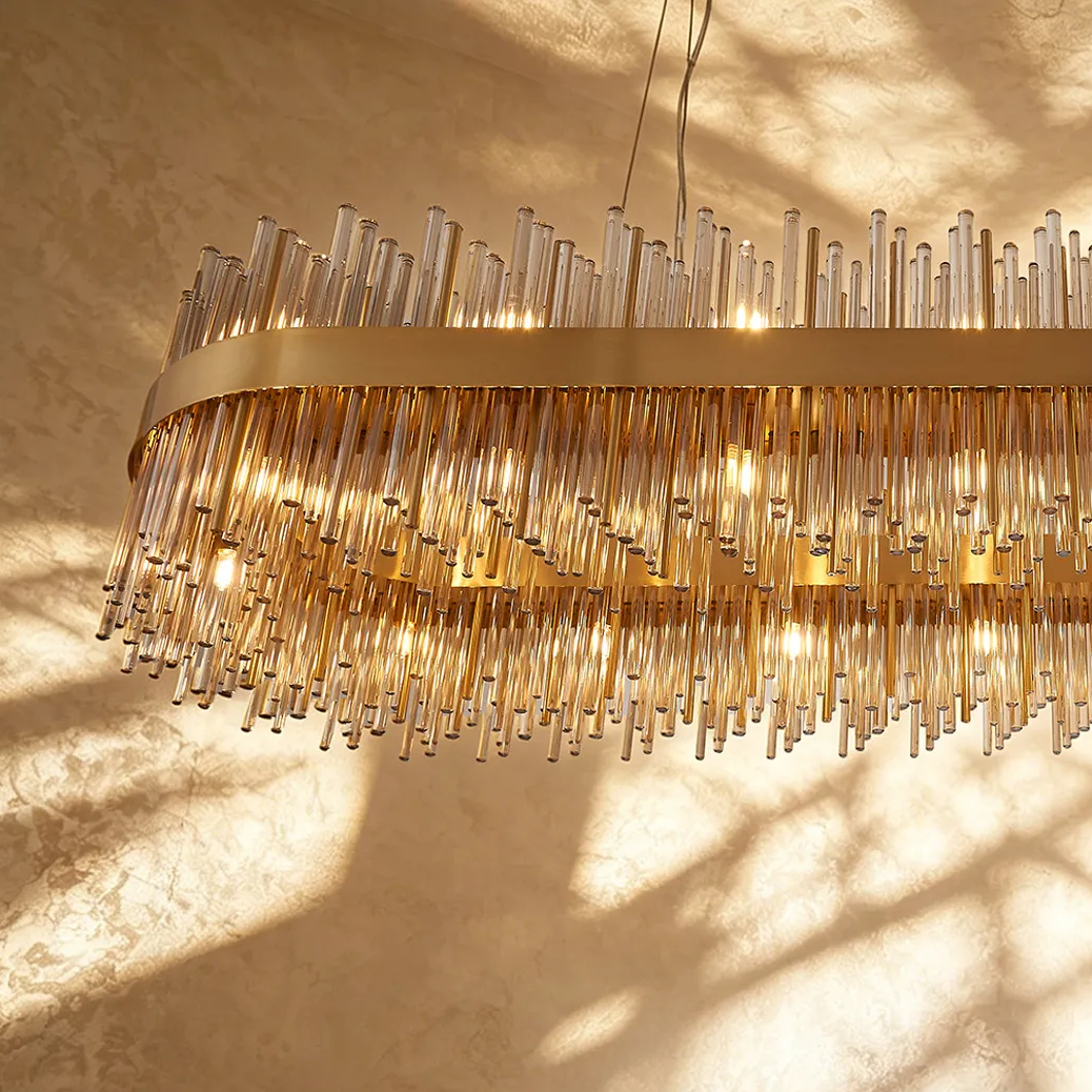 Oval chandelier with many glass rods and warm light