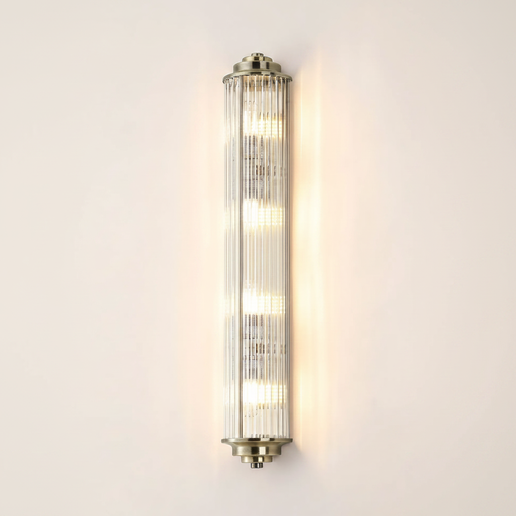 Vertical ribbed glass wall light with brass accents and four illuminated bulbs