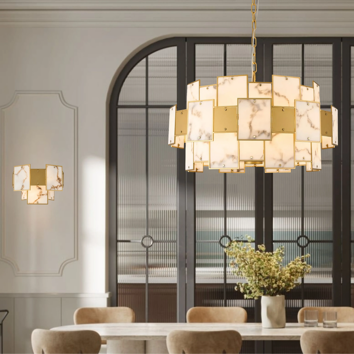 Gold and marble chandelier and matching wall sconce in a dining room