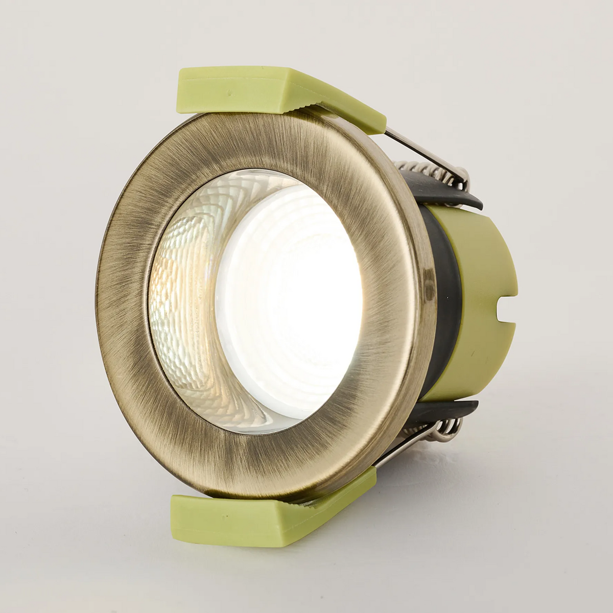 Side view of an antique brass downlight with a cool white light