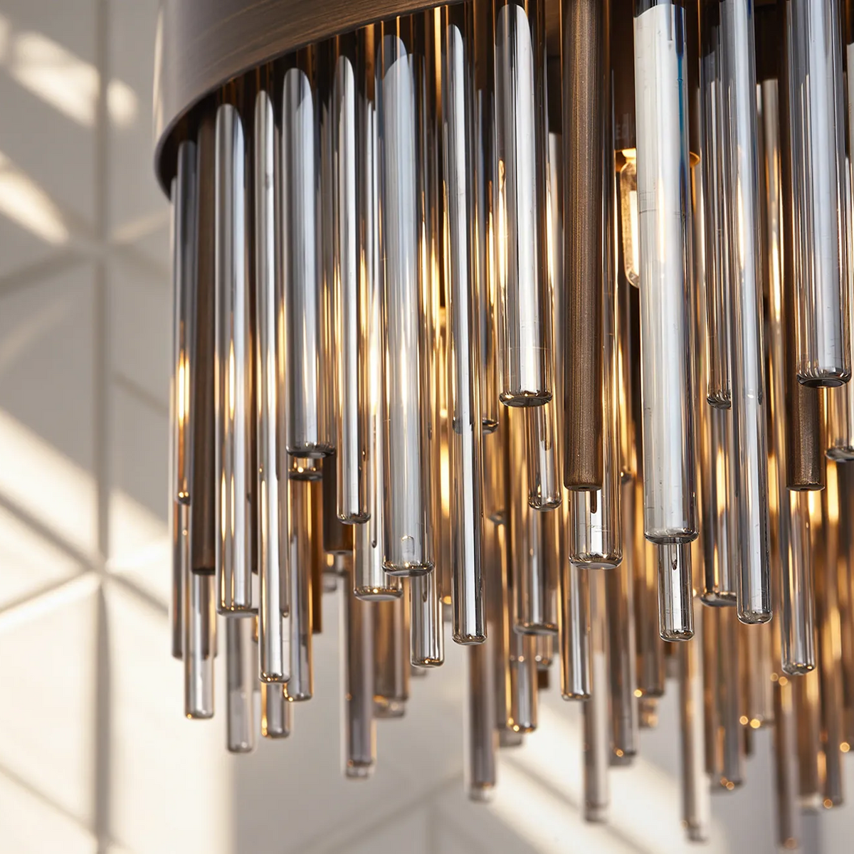 Close up of a chandelier with multiple glass tubes hanging down, some clear, some tinted brown