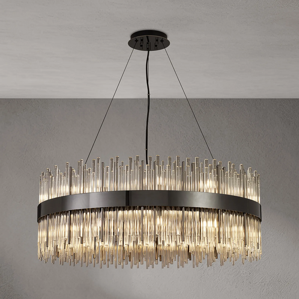 Round chandelier with a dark metal band and numerous clear glass rods hanging down, illuminated from within