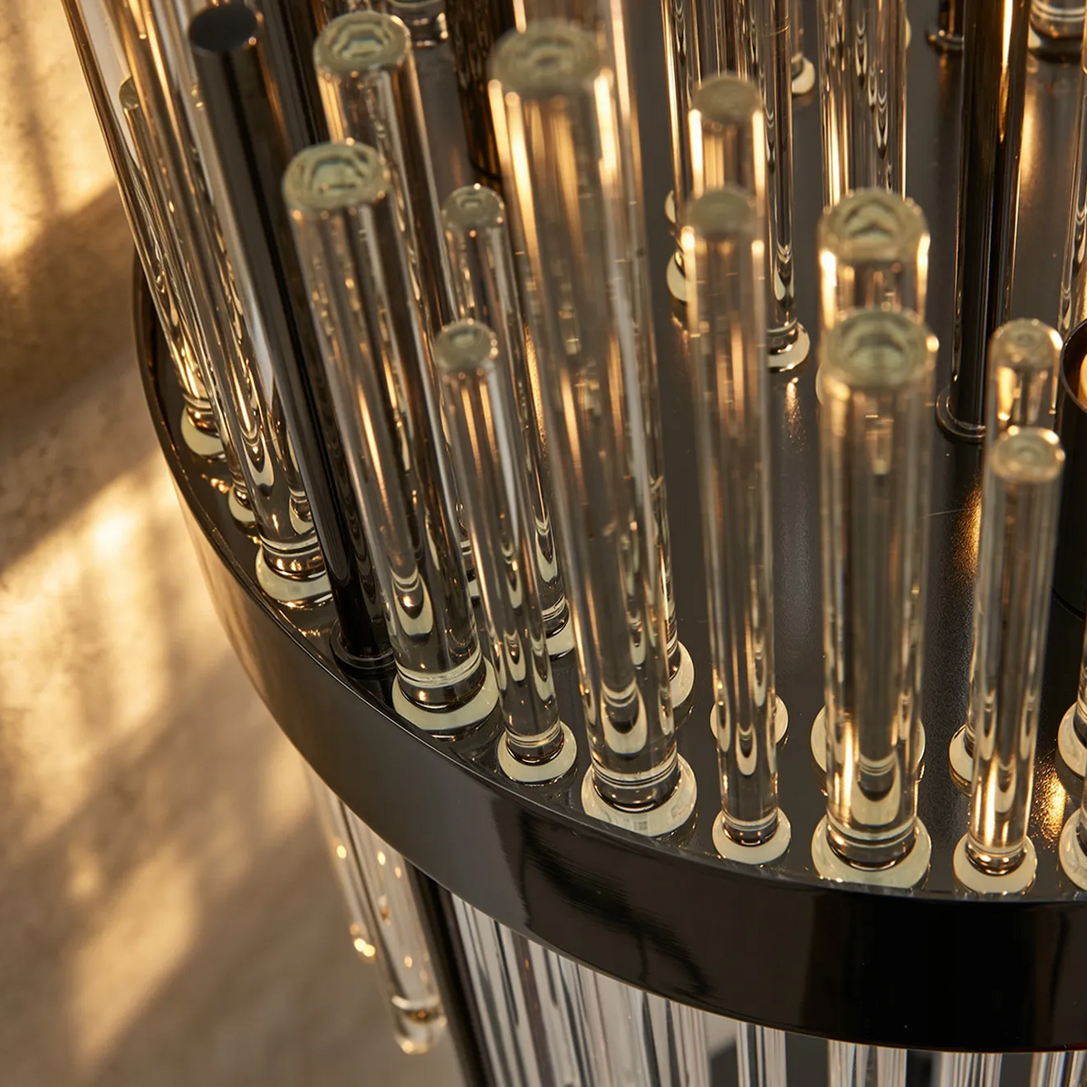Close up of a black chandelier base with many clear glass rods