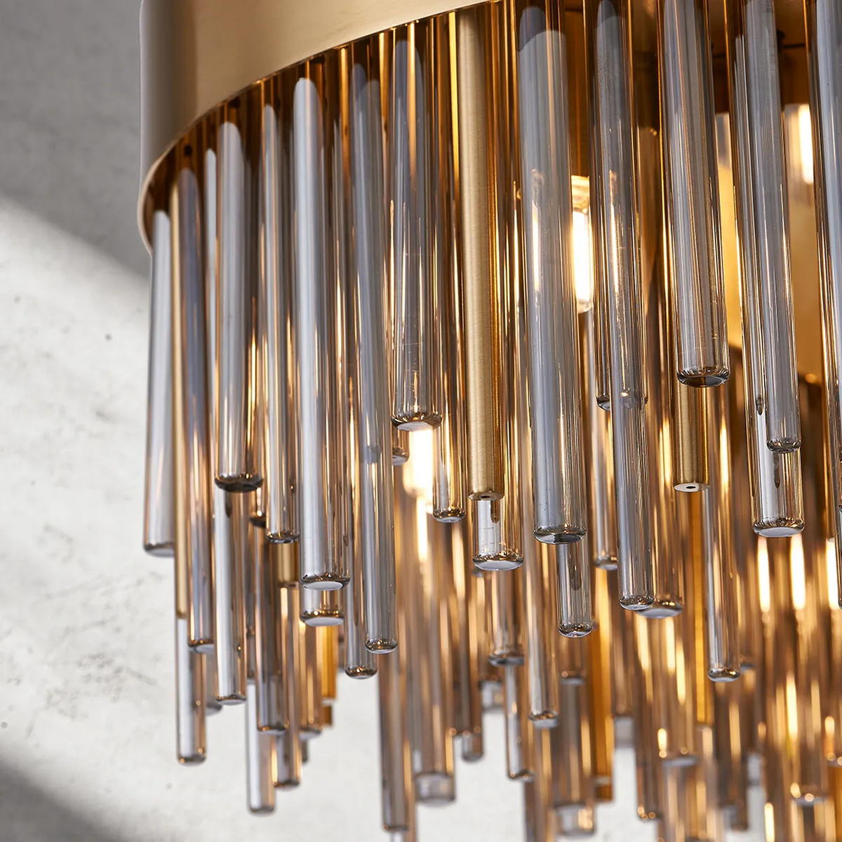Close up of a gold and glass chandelier with many glass rods hanging down